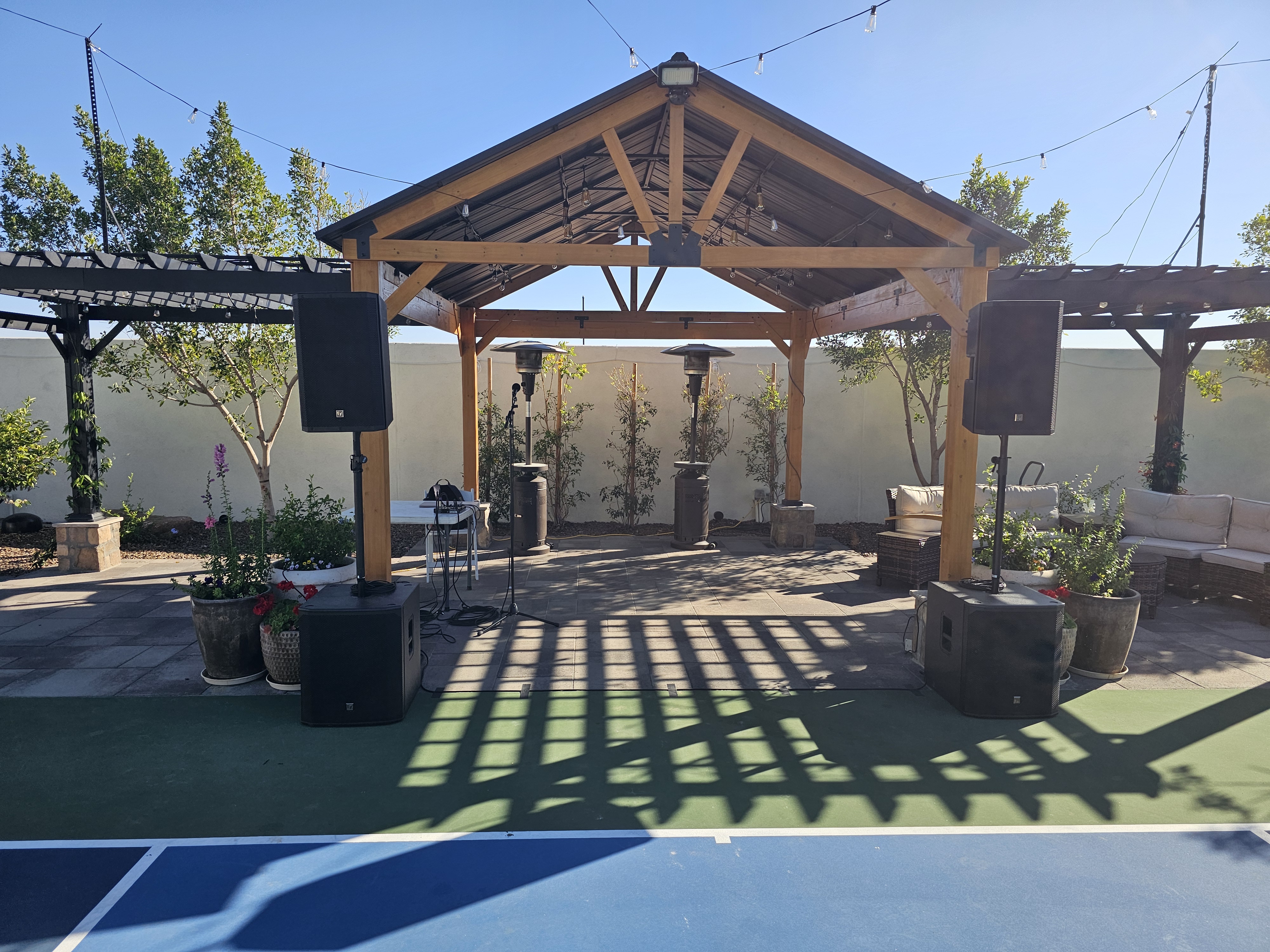 Professional DJ setup under a wood pavilion with string lights
