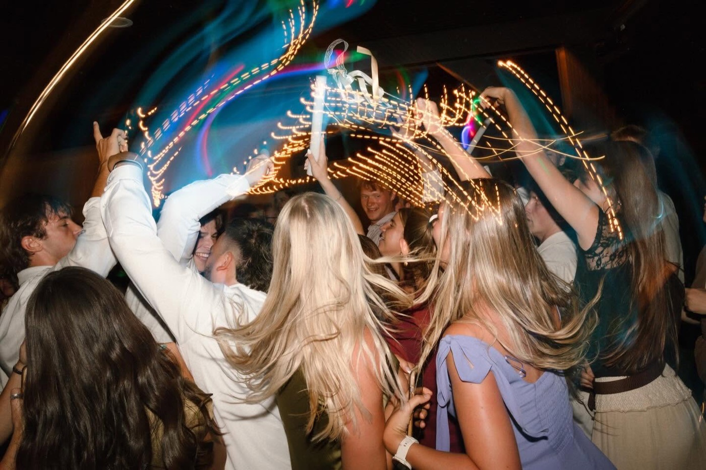 High-energy dance floor with light trails from DJ lighting
