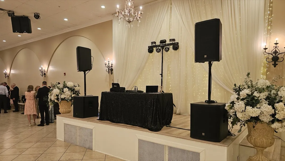Professional DJ setup on stage with EV speakers, subs, and lighting at an elegant venue